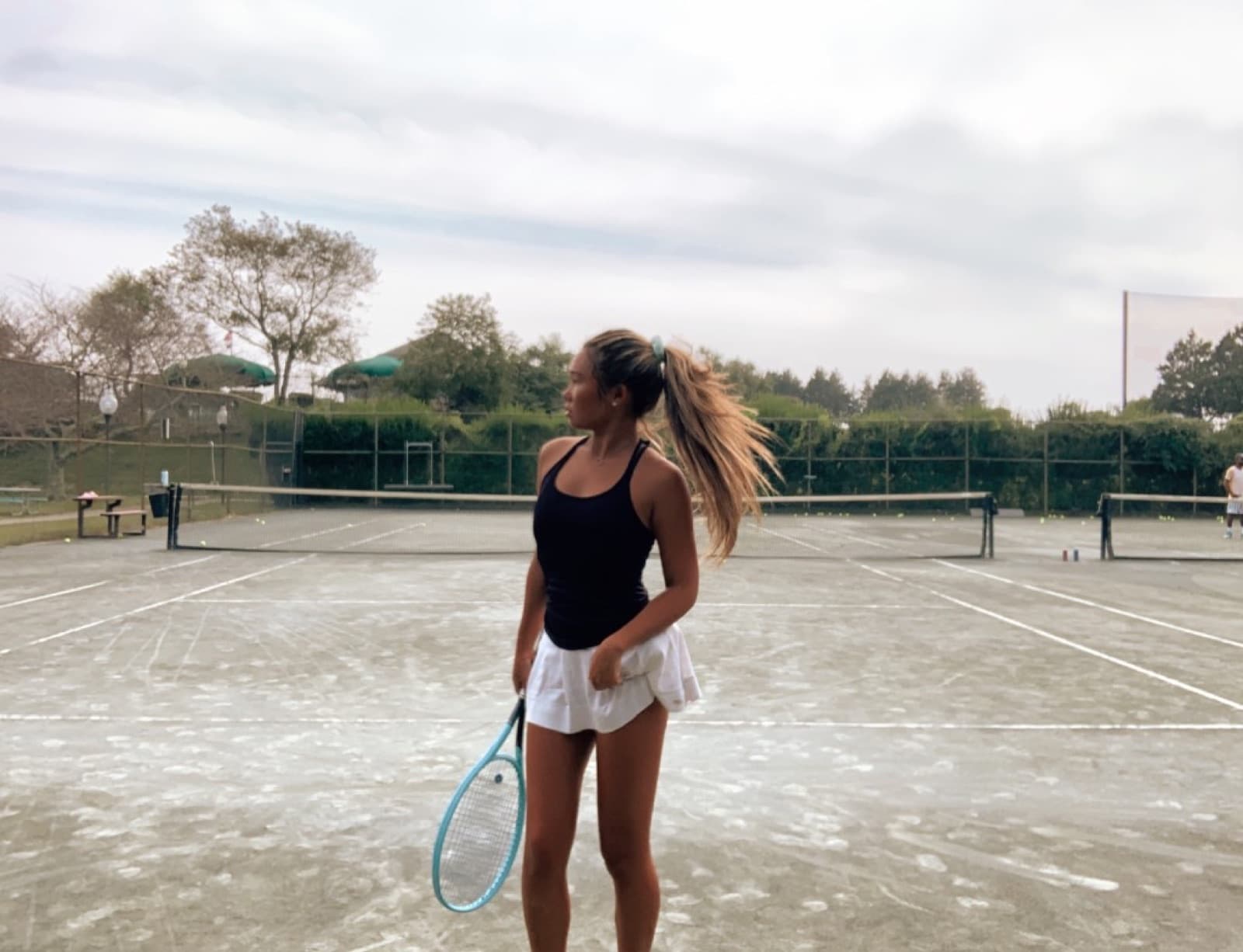 Bolor standing on a clay court at practice, racket in hand, reading the next ball.