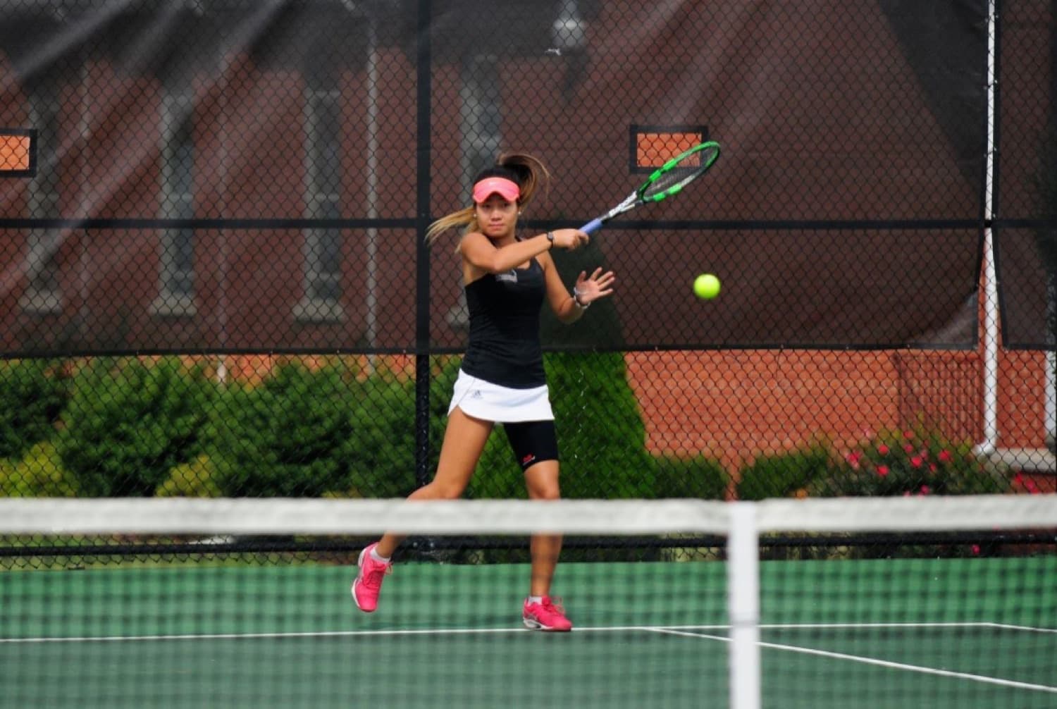Bolor hitting a forehand through the ball at the baseline.