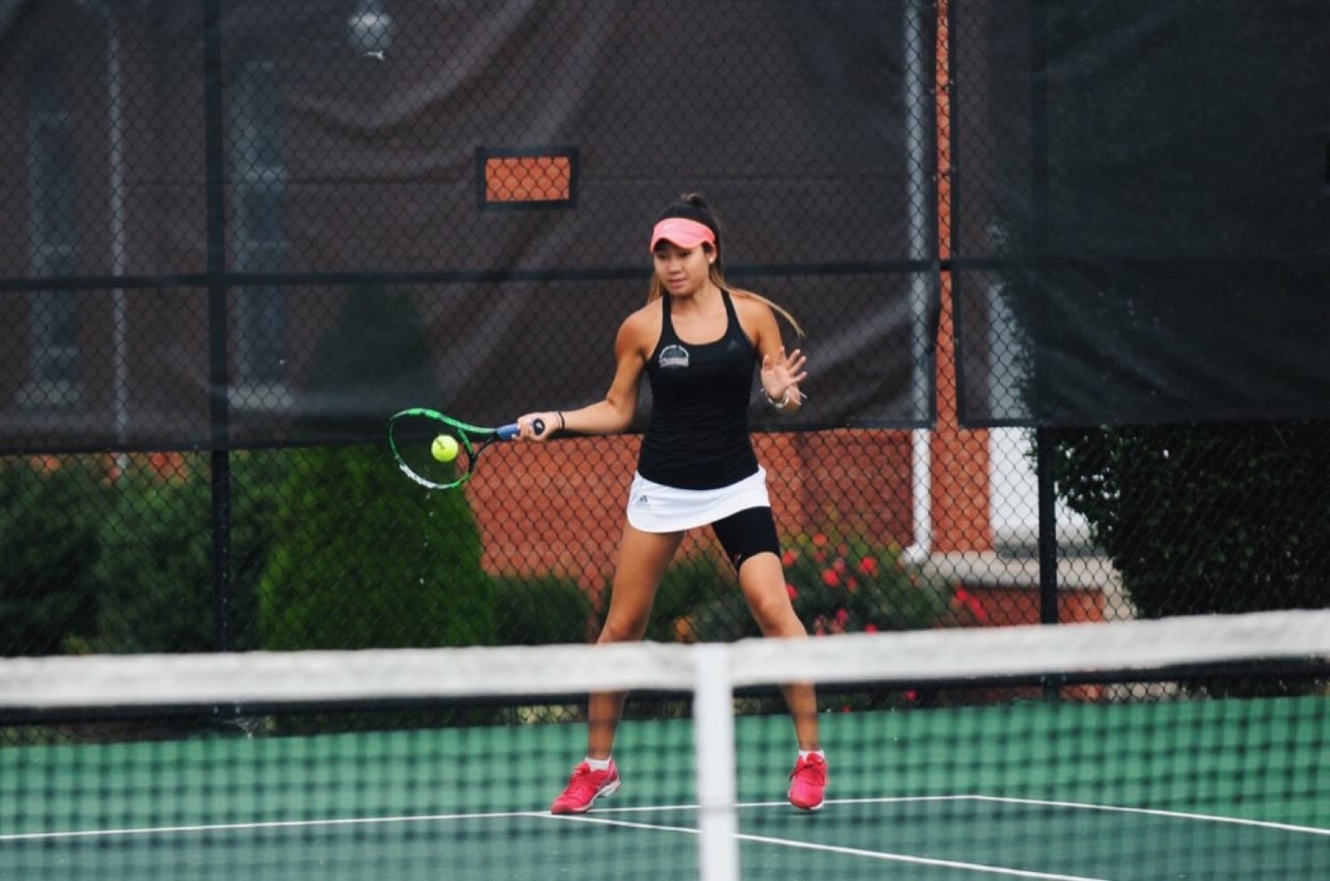 Bolor stepping into a forehand at the net during a match.